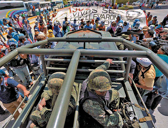 Normalistas
            Ayotzinapa bloquean militares en Autopista del Sol, 5 de
            octubre de 2014.