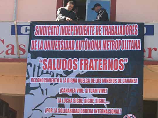 Workers hang banner of solidarity
            greetings from Union of Workers of the Metropolitan
            Autonomous University (SITUAM) to striking Cananea miners,
            December 2007. Banner says For International Workers
            Solidarity! (Photo: El Internacionalista)