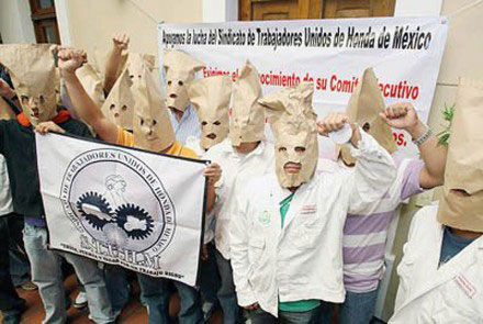 Honda workers members of independent
            union STUHM wearing bags over their heads to avoid
            identification, December 2010. (Photo: La Jornada)