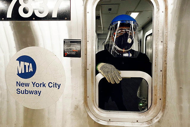 NYC subway conductor with full face shield. (Photo:
                Fortune magazine)